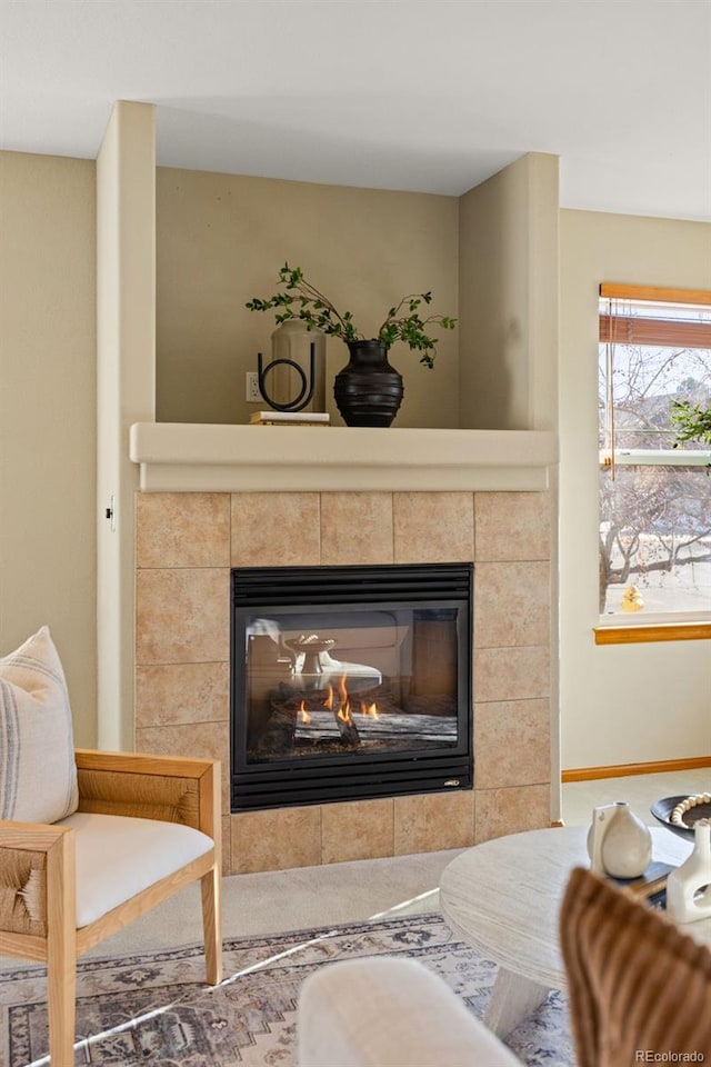 living area featuring a tiled fireplace