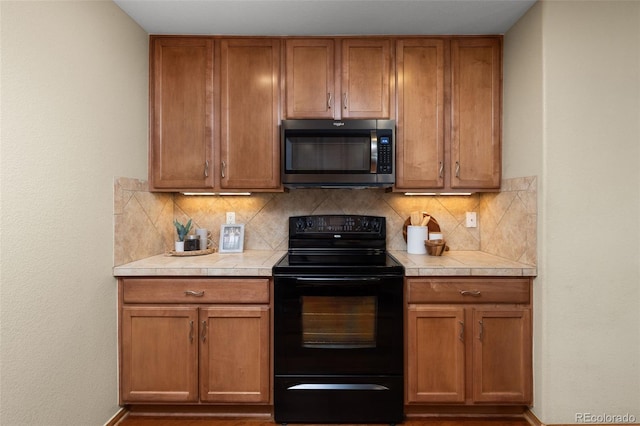 kitchen with black electric range and decorative backsplash