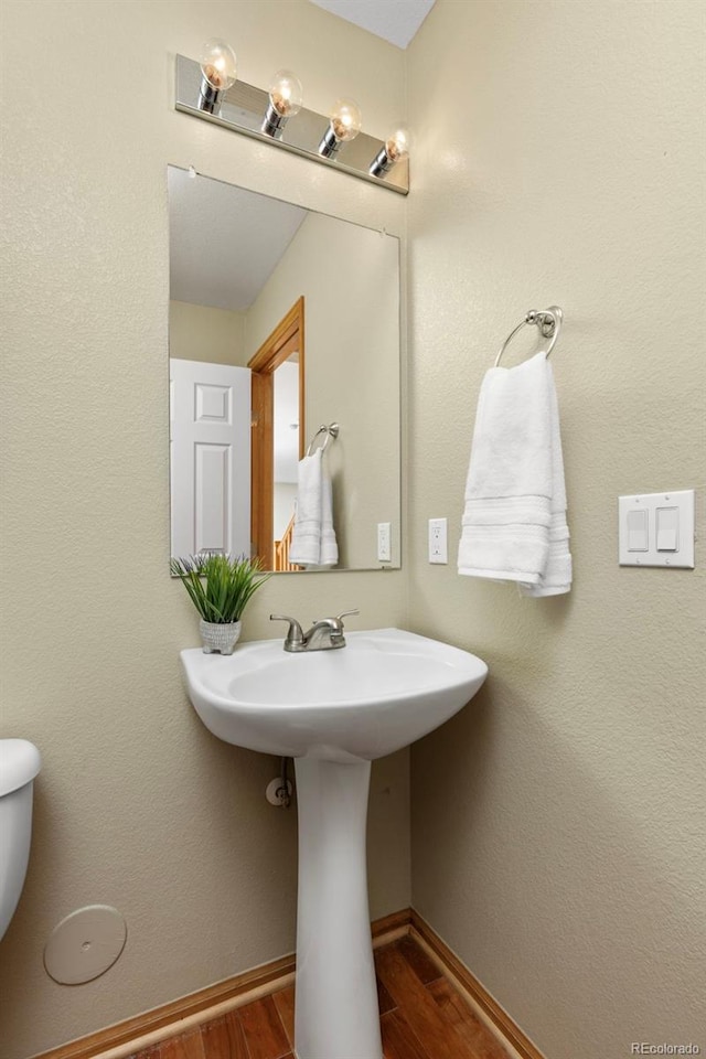 bathroom featuring hardwood / wood-style flooring and toilet