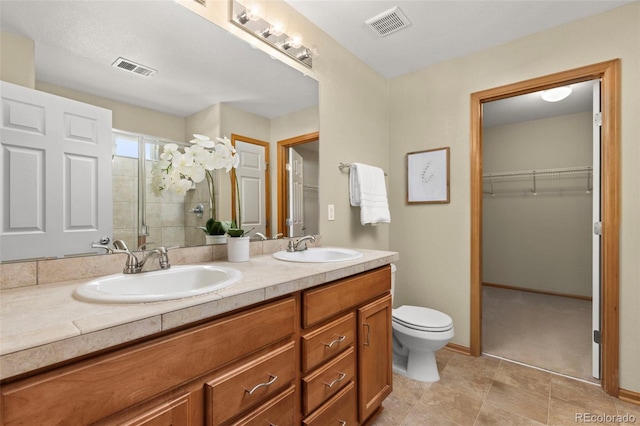 bathroom featuring vanity, toilet, and an enclosed shower