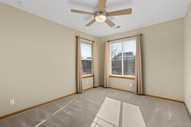 carpeted spare room featuring ceiling fan