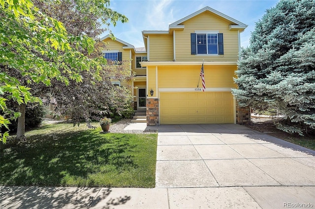 view of front of home with a garage, concrete driveway, stone siding, and a front yard