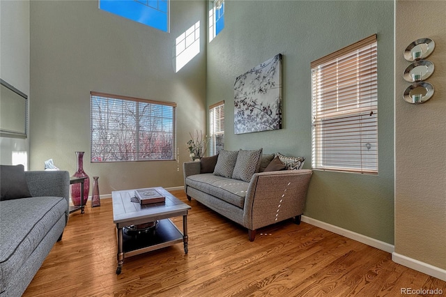 living room featuring plenty of natural light, light wood-style flooring, and baseboards