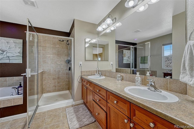 full bath with double vanity, visible vents, a garden tub, a shower stall, and a sink