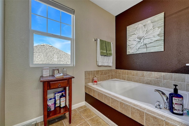 bathroom featuring tile patterned flooring, a textured wall, baseboards, and a bath