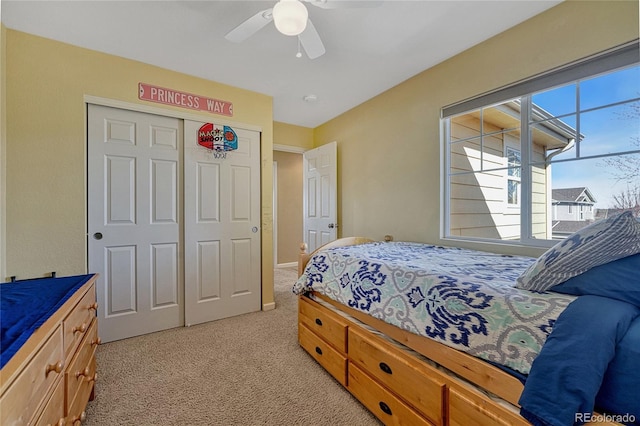 bedroom featuring light carpet, ceiling fan, and a closet