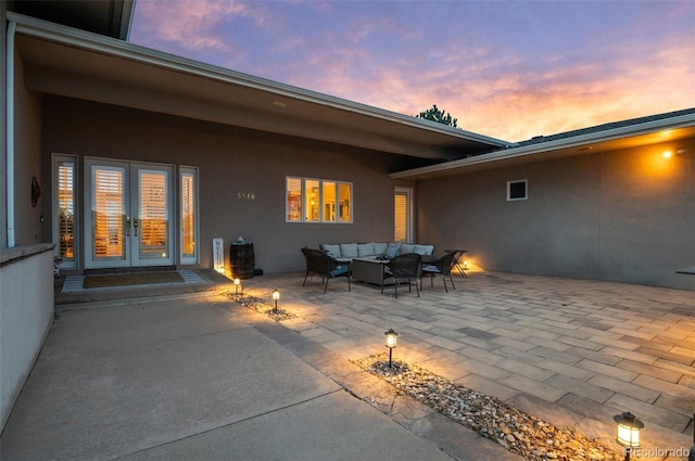 patio terrace at dusk featuring an outdoor living space and french doors