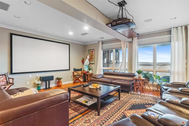 home theater featuring recessed lighting, visible vents, wood finished floors, and crown molding