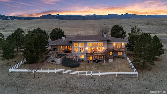 back of house featuring stairs, a patio, a fenced backyard, and a mountain view