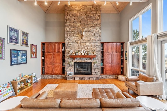 living room with wooden ceiling, rail lighting, a fireplace, and wood finished floors