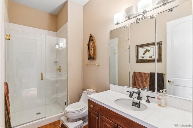 bathroom with vanity, a shower stall, and toilet