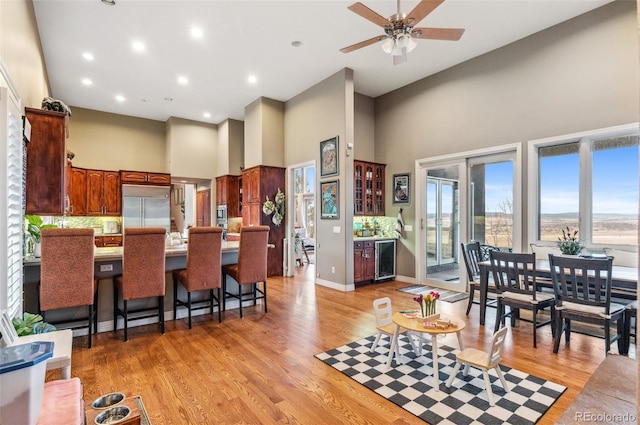 kitchen with wine cooler, built in refrigerator, tasteful backsplash, and light wood finished floors