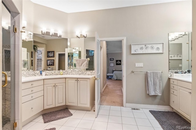 ensuite bathroom with visible vents, two vanities, a stall shower, connected bathroom, and tile patterned flooring