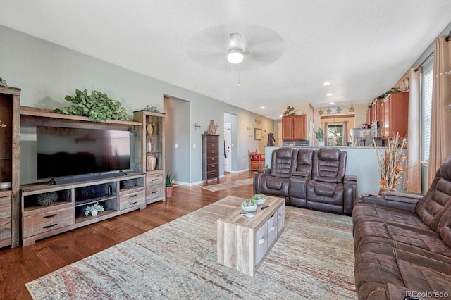 living room featuring ceiling fan, light hardwood / wood-style floors, and a textured ceiling