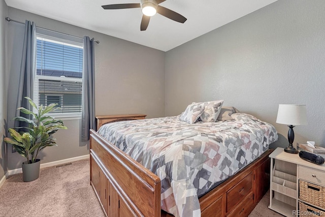 bedroom with visible vents, baseboards, ceiling fan, and light colored carpet