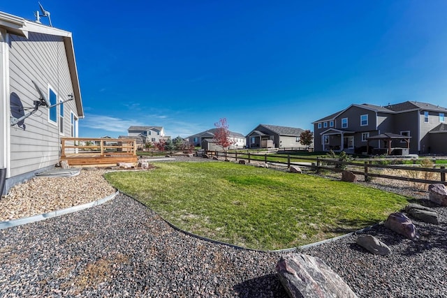 view of yard featuring a residential view, fence, and a deck