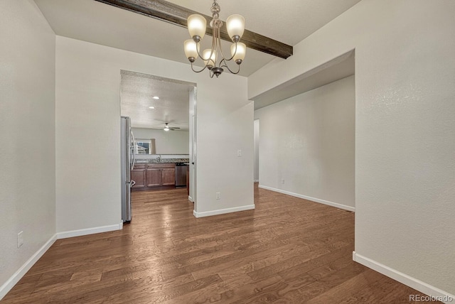 unfurnished dining area with dark wood-type flooring, a sink, beam ceiling, and baseboards