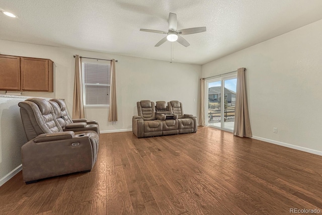 living room with ceiling fan, baseboards, dark wood finished floors, and a textured ceiling