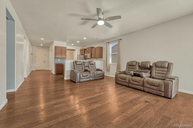 living area with baseboards, dark wood finished floors, a ceiling fan, a textured ceiling, and recessed lighting