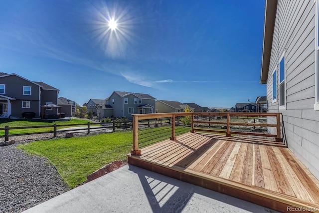 wooden deck featuring a lawn and a residential view