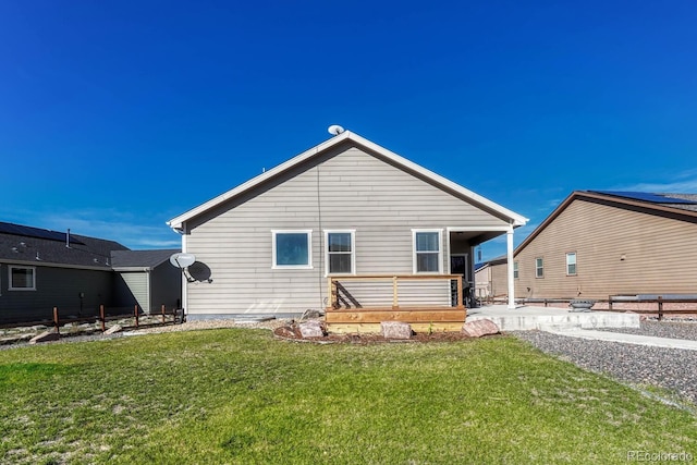 rear view of house with a deck and a yard