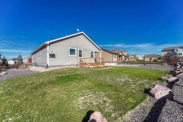 rear view of house with a residential view, a lawn, and a wooden deck