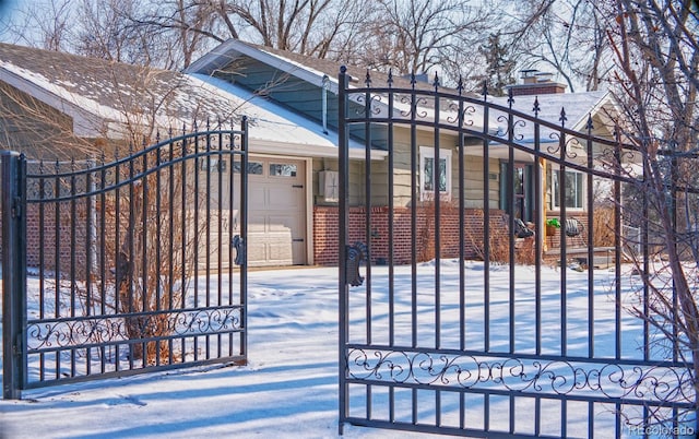 snow covered gate featuring a garage