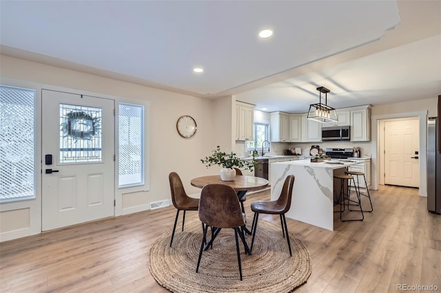 dining area with sink and light hardwood / wood-style floors