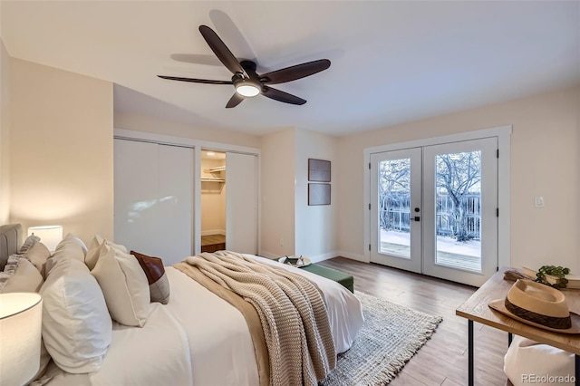 bedroom featuring wood-type flooring, a walk in closet, access to outside, ceiling fan, and french doors