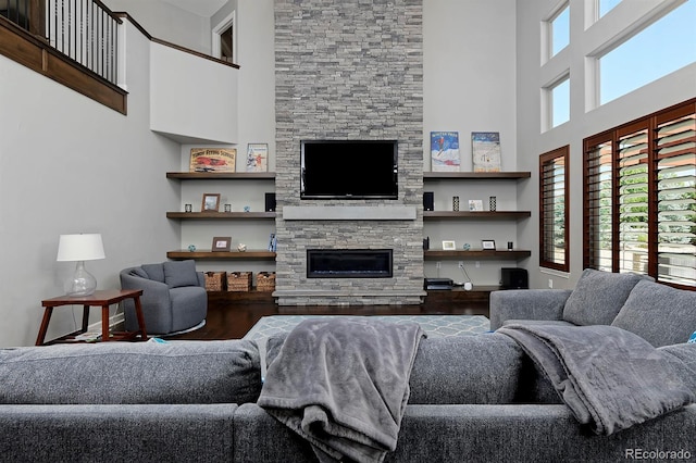 1315 W 141st Cir, Westminster, CO 80023 - living area featuring a towering ceiling, plenty of natural light, wood finished floors, and a stone fireplace