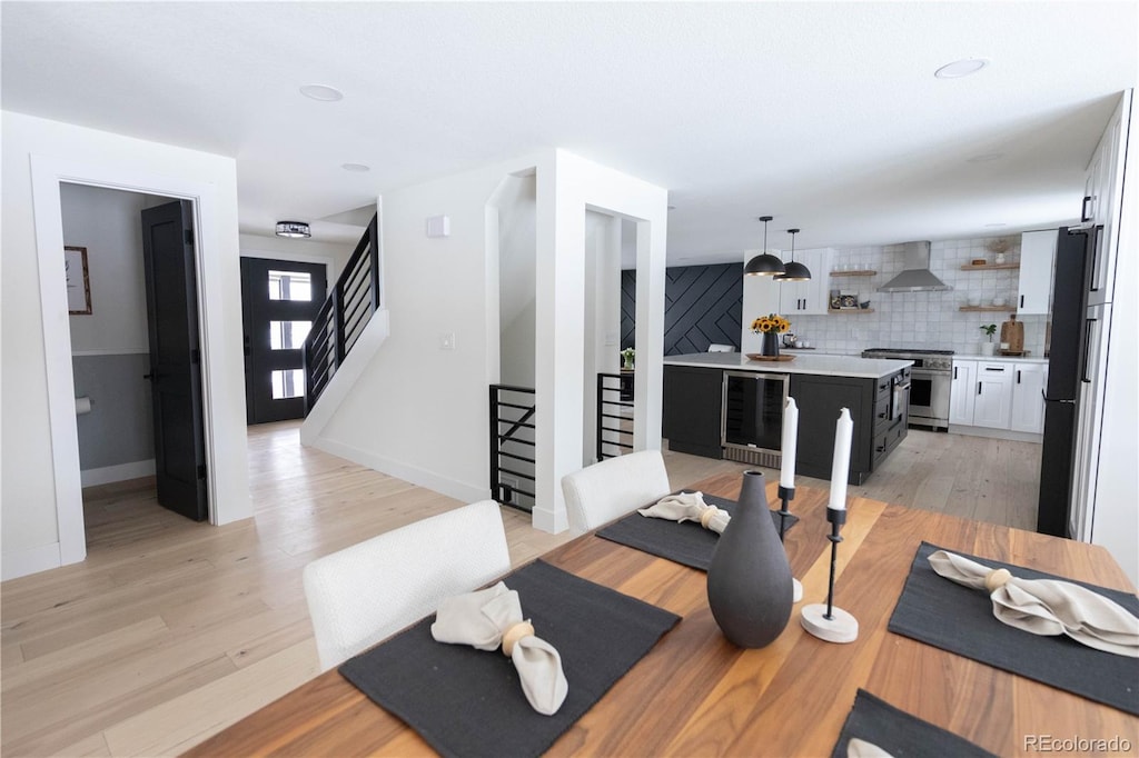 workout room with light hardwood / wood-style floors and beverage cooler