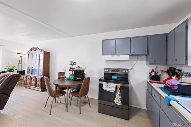 1112 W Mesa Ave Unit 1114, Pueblo, CO 81004 - kitchen featuring range with electric stovetop, under cabinet range hood, gray cabinets, open floor plan, and light wood finished floors