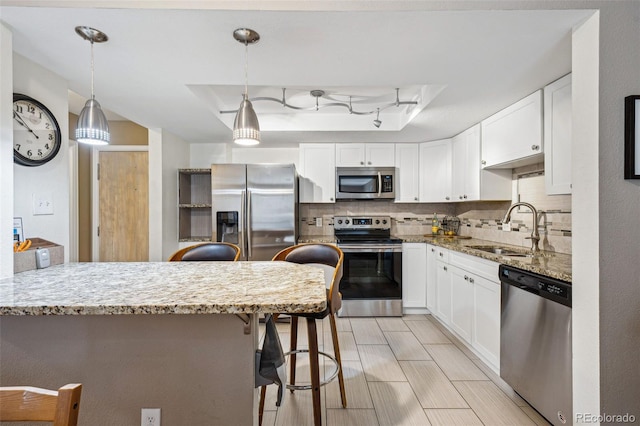 kitchen featuring white cabinets, appliances with stainless steel finishes, and light stone counters