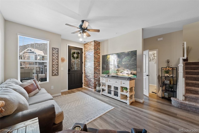 living room featuring ceiling fan, stairway, wood finished floors, and baseboards