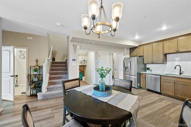 dining space with light wood finished floors, baseboards, stairway, a notable chandelier, and recessed lighting