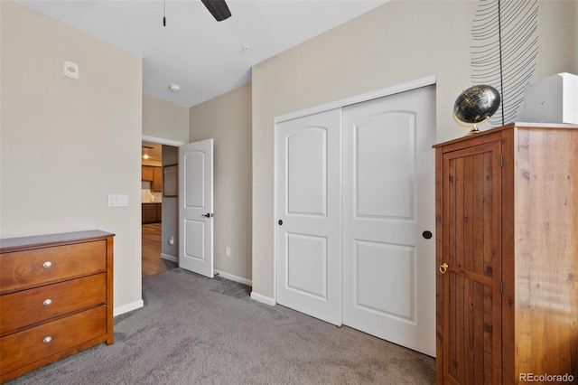 unfurnished bedroom featuring a ceiling fan, a closet, baseboards, and carpet flooring