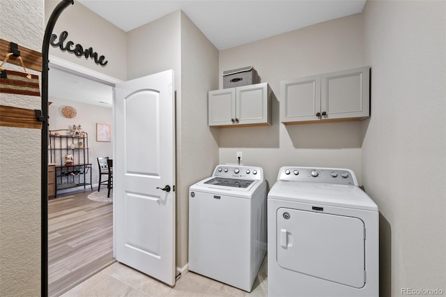 washroom with cabinet space and independent washer and dryer