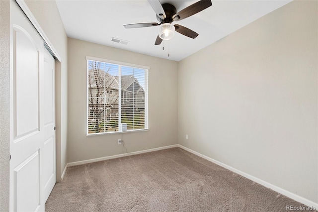 unfurnished bedroom with carpet flooring, baseboards, visible vents, and a closet