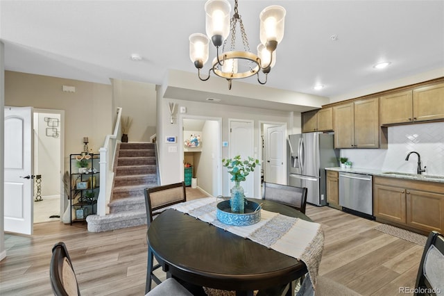 dining space featuring light wood-style floors, stairs, baseboards, an inviting chandelier, and recessed lighting