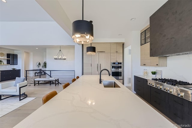 kitchen featuring appliances with stainless steel finishes, decorative light fixtures, light stone countertops, and sink