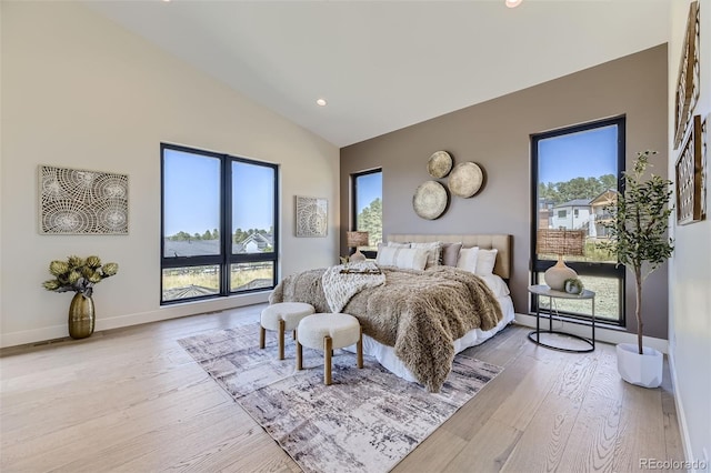 bedroom with lofted ceiling and light hardwood / wood-style floors