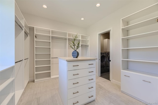 spacious closet with washer and dryer and light colored carpet