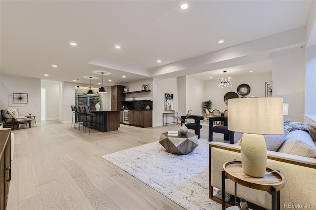 living room with a chandelier and light hardwood / wood-style floors