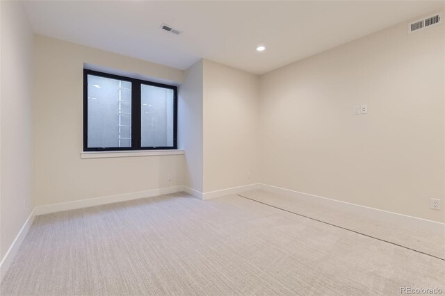 unfurnished room featuring light carpet