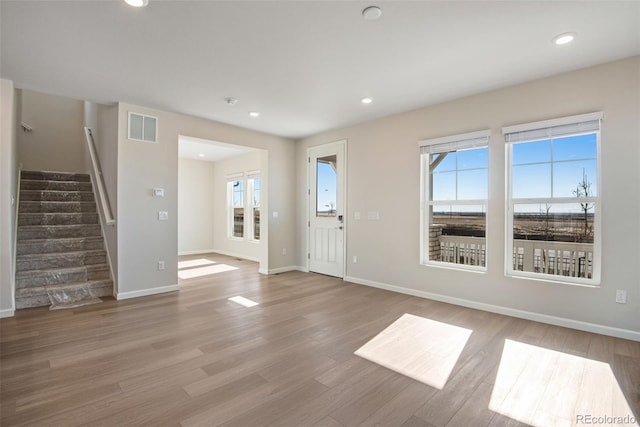 entryway featuring a healthy amount of sunlight, visible vents, light wood finished floors, and stairs