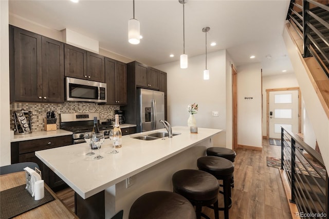 288 Lions Gate Dr, Winter Park, CO 80482 - kitchen featuring appliances with stainless steel finishes, a sink, a kitchen bar, tasteful backsplash, and recessed lighting