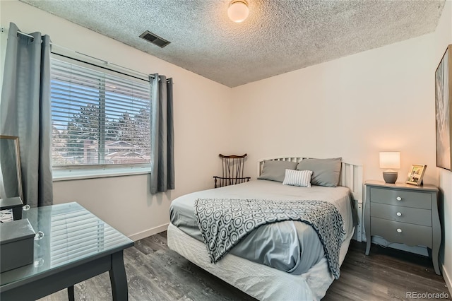 bedroom featuring dark hardwood / wood-style floors and a textured ceiling