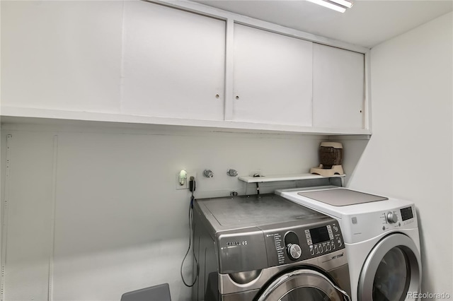 washroom featuring cabinets and washer and dryer