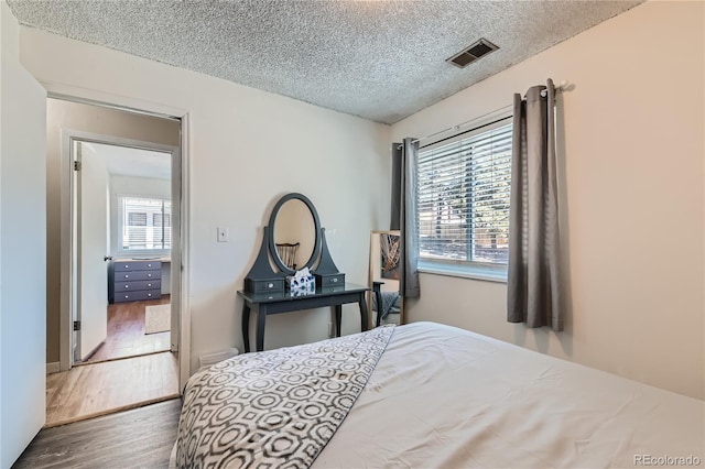 bedroom featuring dark wood-type flooring and a textured ceiling