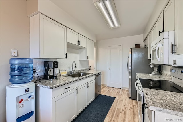 kitchen with sink, tasteful backsplash, light wood-type flooring, white appliances, and white cabinets